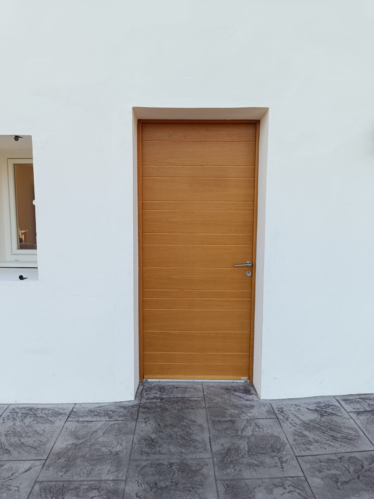 Vue extérieure de la porte Zilten en chêne clair posée par Zabal Menuiseries à Halsou