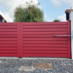Portail aluminium rouge La Toulousaine Stendal avec motorisation sur maison à Ustaritz