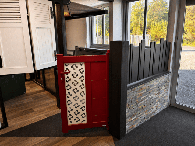 Portail et clôture aluminium – showroom Zabal Lescar Portail rouge et clôture aluminium exposés au showroom Zabal Menuiseries de Lescar près de Pau