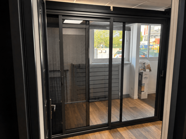 Baie coulissante aluminium – showroom Lescar Baie vitrée coulissante en aluminium noir exposée au showroom Zabal Menuiseries de Lescar près de Pau